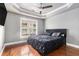Primary bedroom with tray ceiling, ceiling fan, and window providing natural light and outdoor views at 2114 Gorman Se Grv, Atlanta, GA 30316