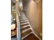 Well-lit staircase with wooden steps and white banister, connecting multiple floors of the home at 3269 N Winds N Trl, Douglasville, GA 30135