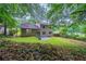 Scenic backyard featuring a well-maintained lawn, mature trees, a stone patio, and partial fencing for privacy at 765 Martin Rd, Stone Mountain, GA 30088