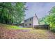 Expansive backyard view showcasing the home's exterior, a fenced yard, a patio, and lush greenery at 765 Martin Rd, Stone Mountain, GA 30088