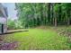 View of a spacious, green backyard with a mix of manicured lawn and natural wooded area, providing a private setting at 765 Martin Rd, Stone Mountain, GA 30088