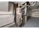 Water heater with piping in a garage and white painted brick walls, sitting on a metal platform at 765 Martin Rd, Stone Mountain, GA 30088