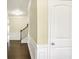 Inviting hallway featuring hardwood floors, wainscoting, and staircase leading to the upper level at 3179 Woodward Down Trl, Buford, GA 30519