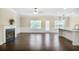 Open-concept living room with fireplace, dark wood floors, and ample natural light at 3179 Woodward Down Trl, Buford, GA 30519