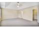 Bright primary bedroom featuring a tray ceiling, neutral carpet, and a walk-in closet at 3179 Woodward Down Trl, Buford, GA 30519