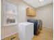 Bright laundry room features wood floors, front loading washer and dryer, and overhead cabinets at 5711 Brynwood Nw Cir, Acworth, GA 30101