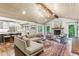 Spacious living room featuring a fireplace, hardwood floors, a beamed ceiling, and an open view to the kitchen at 80 Maryeanna Dr, Sandy Springs, GA 30342