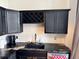 Kitchen featuring black cabinets, granite countertops, and built-in wine rack at 20 Marietta Nw St # 13C, Atlanta, GA 30303