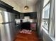 Cozy kitchen featuring stainless steel appliances, black cabinets, and hardwood floors at 20 Marietta Nw St # 13C, Atlanta, GA 30303