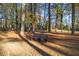 Secluded backyard featuring a comfortable wooden bench under the trees, perfect for relaxation at 200 Mcguirts Bridge Rd, Covington, GA 30014