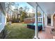 A spacious backyard with green grass, patio furniture, and a covered porch at 200 Mcguirts Bridge Rd, Covington, GA 30014