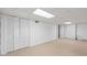 Clean unfinished basement featuring white walls, tile floors, and closet with louvered doors at 200 Mcguirts Bridge Rd, Covington, GA 30014