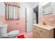 Pink tiled bathroom features a vanity, toilet, medicine cabinet and window at 200 Mcguirts Bridge Rd, Covington, GA 30014