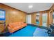 Home gym with wood paneled walls, an orange couch, and blue exercise mat at 200 Mcguirts Bridge Rd, Covington, GA 30014