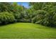 A spacious backyard with lush green lawn, mature trees and red storage shed at 2201 Plantation Ln, Atlanta, GA 30341