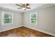 Bedroom with hardwood floors, two windows, ceiling fan, and neutral paint at 2201 Plantation Ln, Atlanta, GA 30341