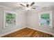 Bedroom with hardwood floors, two windows, ceiling fan, and neutral paint at 2201 Plantation Ln, Atlanta, GA 30341