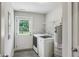 Convenient laundry room with washer, dryer, shelves, hot water heater and door to the outside at 2201 Plantation Ln, Atlanta, GA 30341