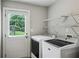 Convenient laundry room with washer, dryer, shelves, and door to the outside at 2201 Plantation Ln, Atlanta, GA 30341