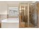 Bathroom featuring a soaking tub, glass enclosed shower, tiled walls, and a window providing natural light at 2720 Tuscany Park Dr, Lawrenceville, GA 30043