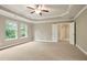 Spacious bedroom with tray ceiling, ceiling fan, neutral walls, carpet, and windows providing natural light at 2720 Tuscany Park Dr, Lawrenceville, GA 30043
