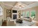 Inviting living room with coffered ceilings, fireplace, custom bookshelves, and large windows offering serene views at 2720 Tuscany Park Dr, Lawrenceville, GA 30043