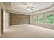 Spacious main bedroom featuring an accent wall, tray ceiling, multiple windows, and carpeted floor at 2720 Tuscany Park Dr, Lawrenceville, GA 30043