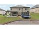 Back exterior showcasing a spacious yard, trampoline, and covered patio for outdoor enjoyment at 3748 Spring Place Ct, Loganville, GA 30052