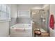 This bathroom offers a soaking tub, a glass shower, and a tile surround at 3748 Spring Place Ct, Loganville, GA 30052