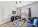 Bright bedroom features a ceiling fan, tv, and blue sofa for a relaxed atmosphere at 3748 Spring Place Ct, Loganville, GA 30052