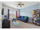 Comfortable bedroom features a blue accent wall, a cozy couch, and plenty of natural light from the window at 3748 Spring Place Ct, Loganville, GA 30052