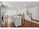 Open kitchen boasts a center island with granite countertops, stainless steel appliances and transitions to a wooden staircase at 3748 Spring Place Ct, Loganville, GA 30052