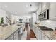 Bright kitchen featuring granite countertops, stainless steel appliances, and an open layout to the living area at 3748 Spring Place Ct, Loganville, GA 30052