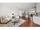 Bright living room with neutral decor and hardwood floors leading to an open kitchen at 3748 Spring Place Ct, Loganville, GA 30052