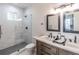 Modern bathroom featuring double sinks, stylish vanity, and a glass-enclosed shower with elegant marble-style tile at 20 S Eugenia Nw Pl, Atlanta, GA 30318