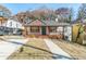 Cozy house exterior with a manicured lawn, covered porch, and ample parking space out front at 20 S Eugenia Nw Pl, Atlanta, GA 30318