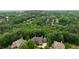 Expansive aerial view of a luxurious home nestled among lush green trees in a private setting at 3155 Wills Mill Rd, Cumming, GA 30041