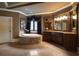 Elegant bathroom featuring a jacuzzi tub with stone detailing and custom cabinetry at 3155 Wills Mill Rd, Cumming, GA 30041