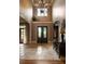 Grand two-story foyer featuring travertine floors, a wrought iron chandelier and arched entryways at 3155 Wills Mill Rd, Cumming, GA 30041