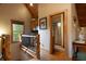 Hallway with a staircase and a view into a kitchen area with wood cabinetry, and a bathroom at 3155 Wills Mill Rd, Cumming, GA 30041