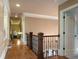 Upstairs hallway with hardwood flooring and decorative railing overlooking the main level at 3155 Wills Mill Rd, Cumming, GA 30041