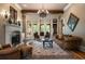 Cozy living room with stone fireplace, large windows, and comfortable leather seating at 3155 Wills Mill Rd, Cumming, GA 30041