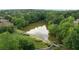 Scenic aerial view of community pond surrounded by lush green trees, grassy areas and walking path at 3155 Wills Mill Rd, Cumming, GA 30041