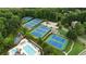 Aerial view of tennis courts, swimming pool, playground, and clubhouse surrounded by mature trees at 3155 Wills Mill Rd, Cumming, GA 30041