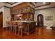 A bar with a granite countertop, dark wood cabinets, twisted columns and room for seating at 3155 Wills Mill Rd, Cumming, GA 30041