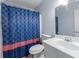 Small bathroom featuring a vanity sink, toilet, and blue patterned shower curtain at 564 Allana Ct, Stone Mountain, GA 30087
