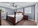 Bedroom with a dark-stained four-poster bed, neutral walls, and plush carpeting at 564 Allana Ct, Stone Mountain, GA 30087
