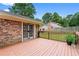 Back deck of a brick home with a wood fence and backyard view at 564 Allana Ct, Stone Mountain, GA 30087