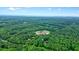 Wide aerial view displays property surrounded by lush green forest and nearby school for added convenience at 5770 Dorsett Shoals Rd, Douglasville, GA 30135