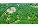 Aerial view showing the property nestled in a wooded area near a tennis court at 5770 Dorsett Shoals Rd, Douglasville, GA 30135